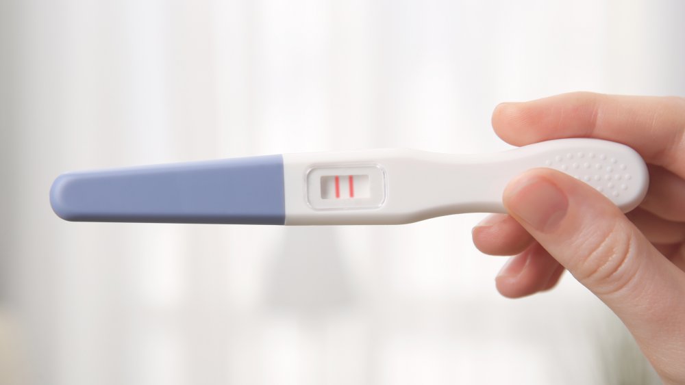 Woman holding a pregnancy test