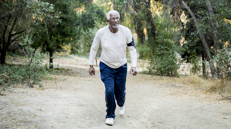 Older man walking through woods