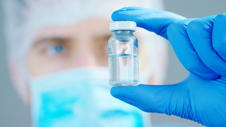 Vet holding vial of anesthesia