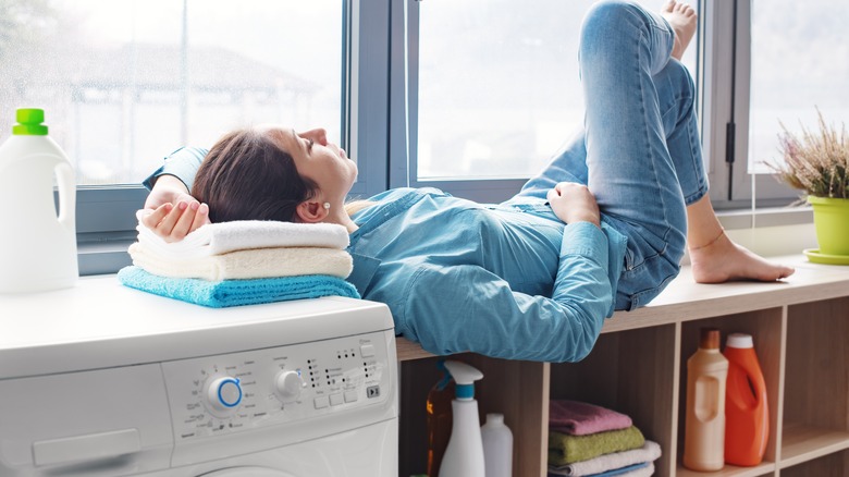 Woman rests on washing machine