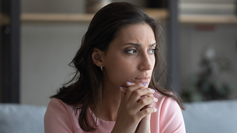 woman sitting on her sofa looking worried