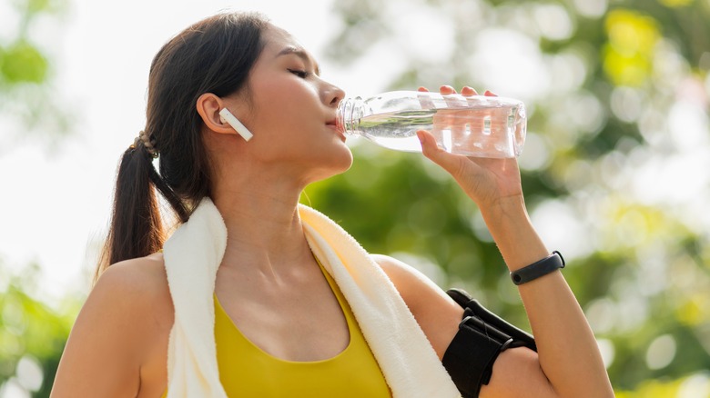 woman drinking water after exercise 