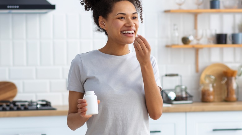 happy woman taking supplements 