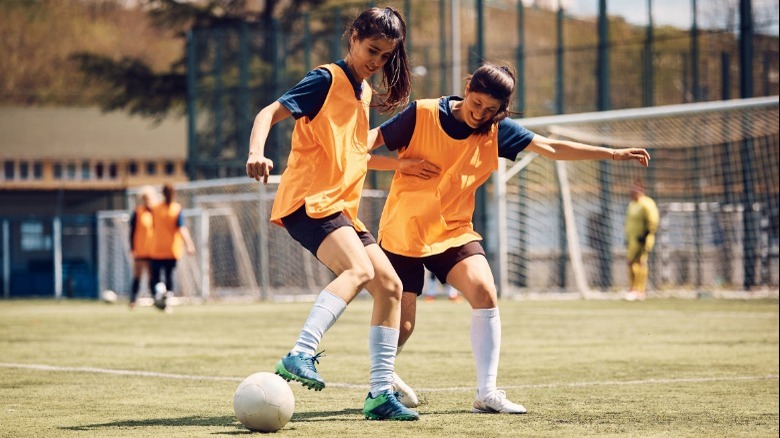 two young women playing soccer