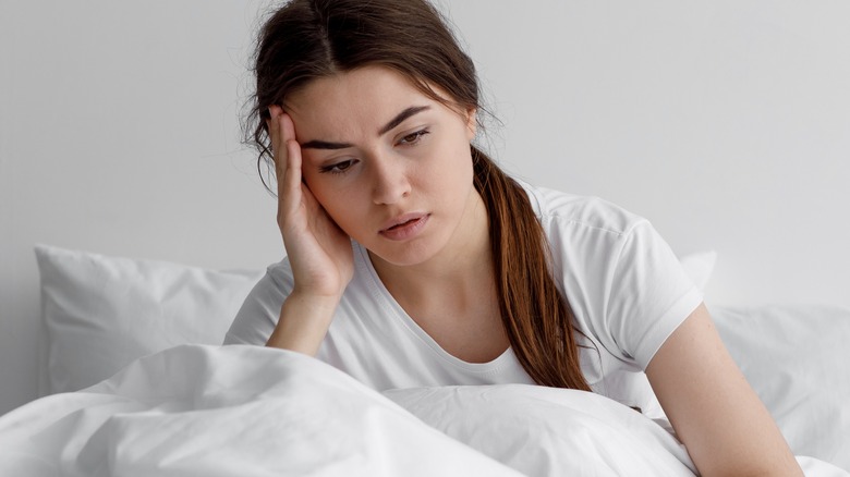 young woman in bed looking tired