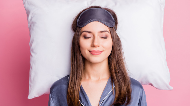 woman sleeping against pink background