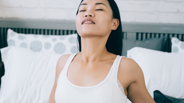 Young woman deep breathing in bed