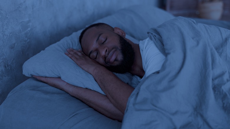 Man sleeping on his side holding his pillow
