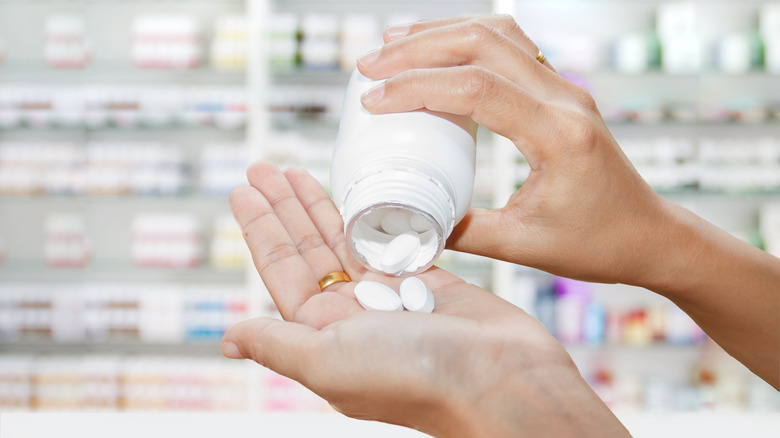 Woman pouring pills into hand