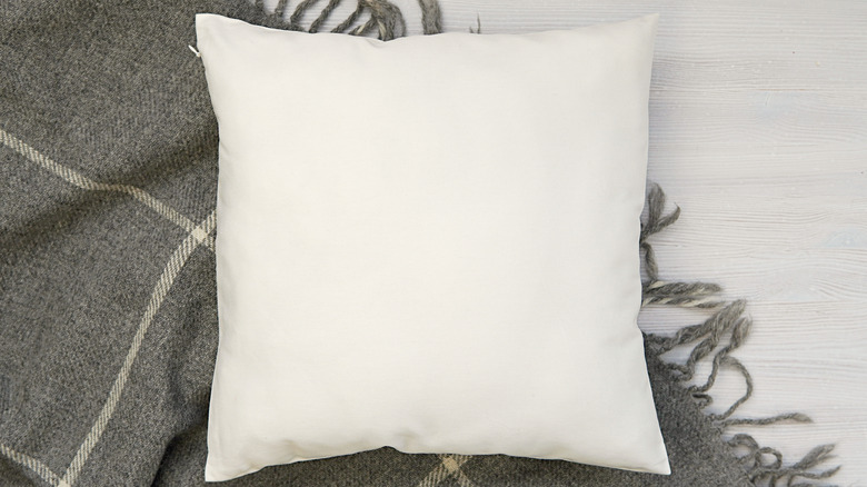 white pillow on blanket