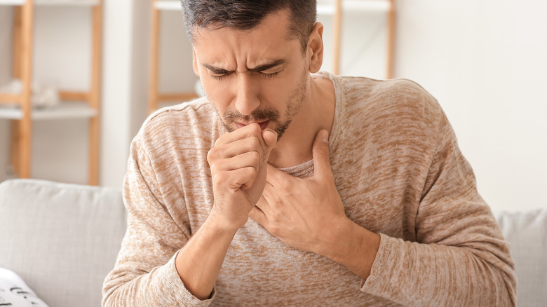 sick man coughing on couch