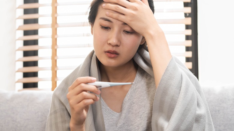 woman with fever on couch