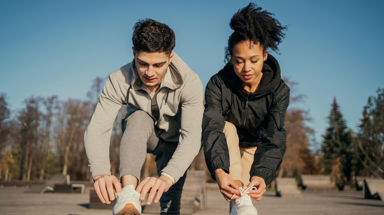 pair of runners lacing up shoes