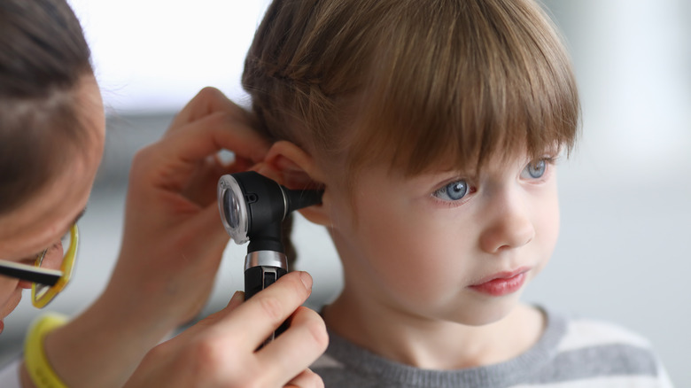 doctor examing ear of child