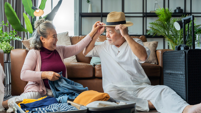 Elderly couple unpacking together from vacation 