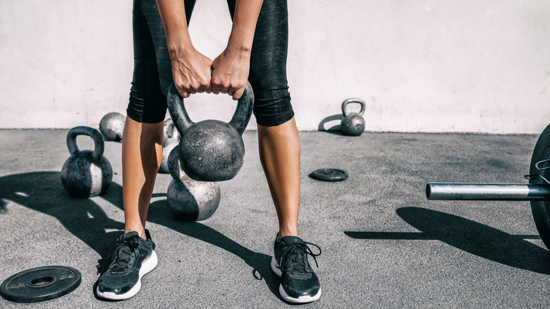 a person lifting a kettle bell