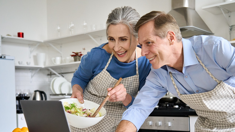 middle aged couple looking at recipes on the computer eating healthy