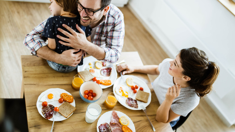 Parents with their child eating a big breakfast