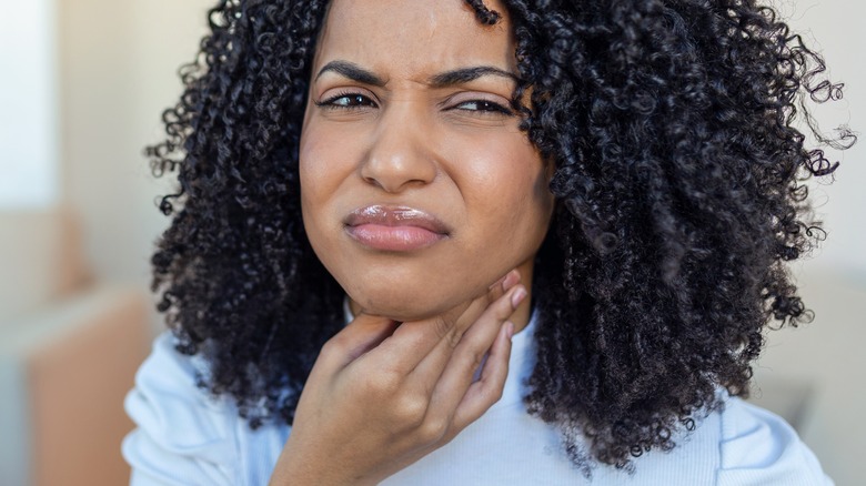 woman holding painful neck