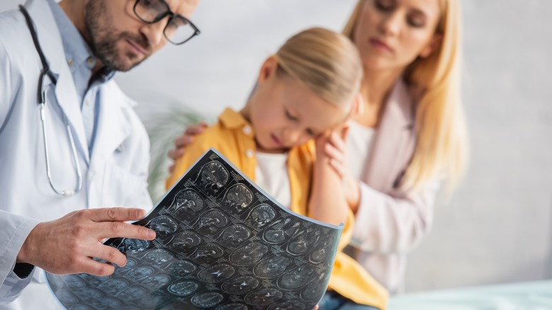 Doctor showing MRI scan to girl and mother