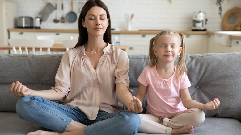 Woman and child meditating on couch