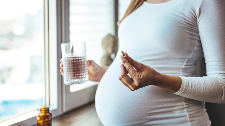 Pregnant woman talking medicine