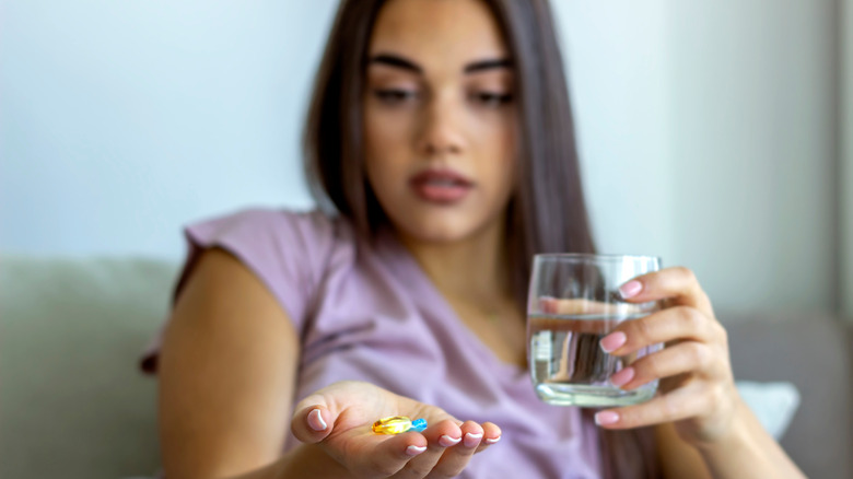 Woman taking medication with water