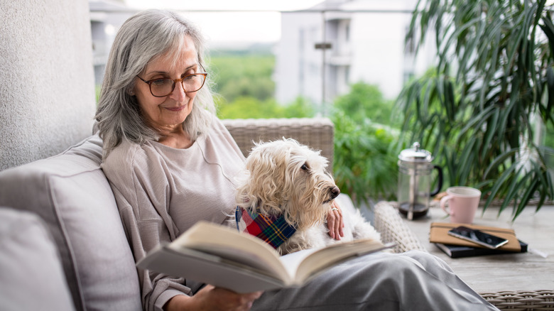 woman reading and relaxing with her dog