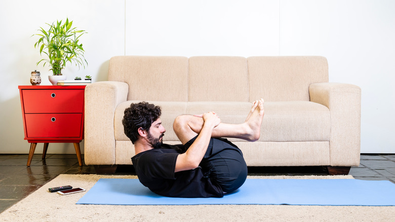 Man doing wind-releasing yoga pose