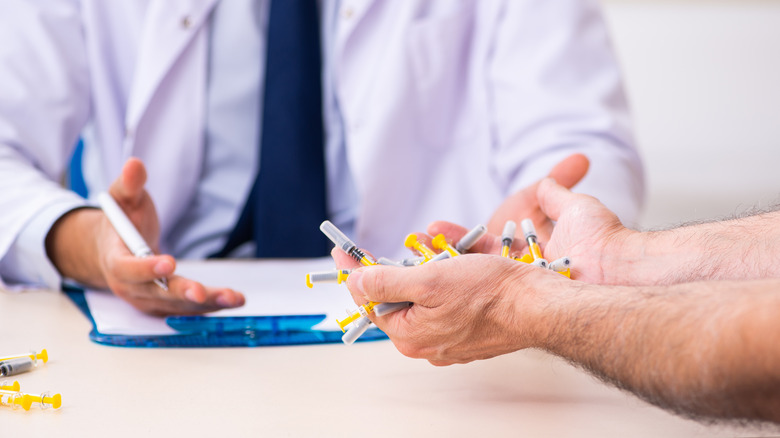 Patient holding multiple injection pens