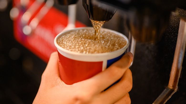 Person getting soda from a soft drink machine