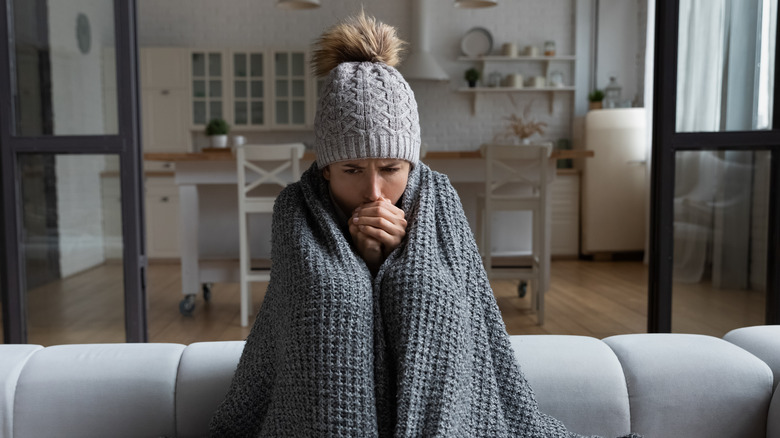 sick woman wrapped in blankets