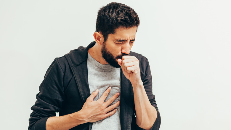 man coughing into his hand