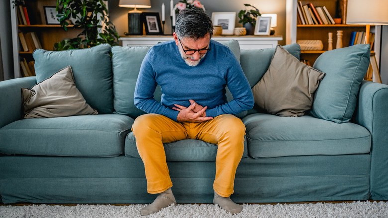 Man with stomach ache on couch