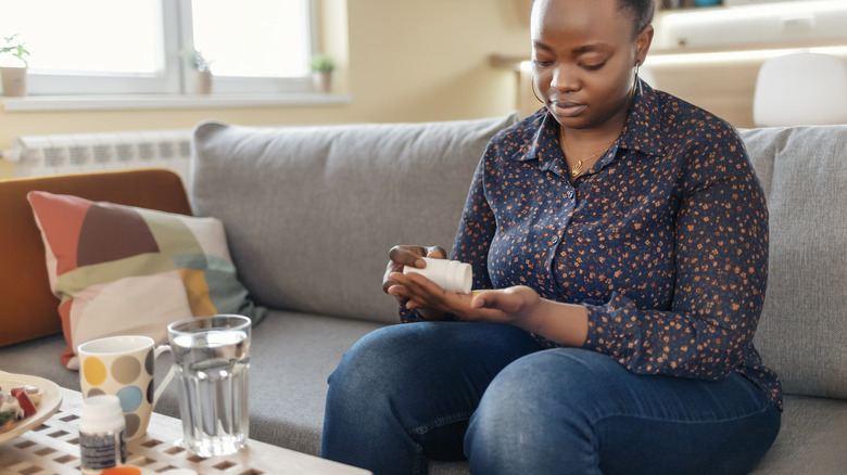 woman on couch taking medication