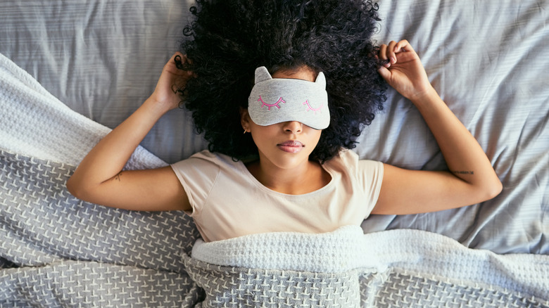 woman with a mask sleeping on her back