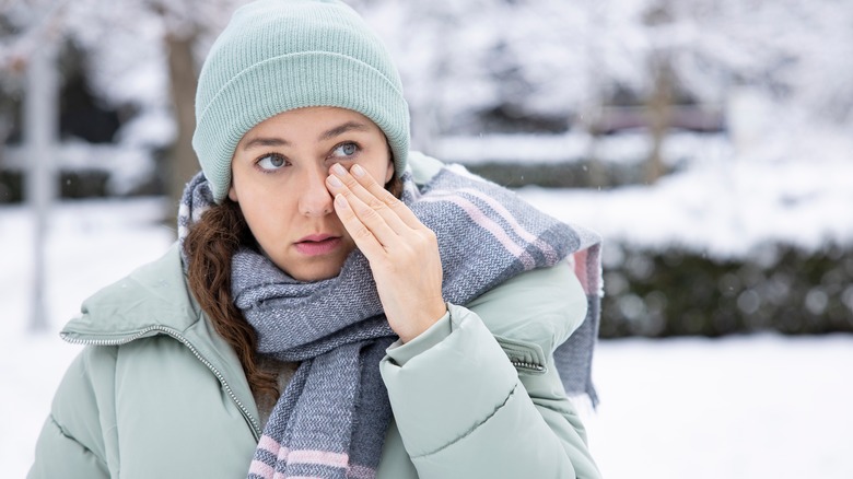 Woman touching eyes in winter