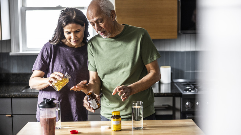 An older couple taking supplements