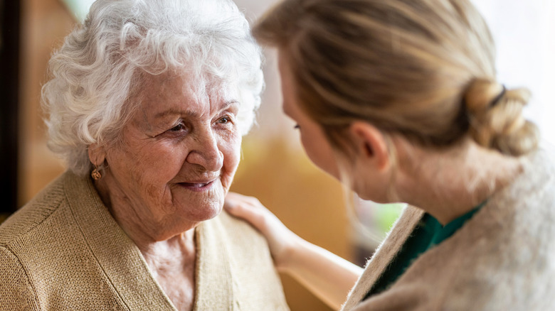 Caregiver comforting older woman