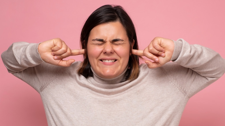 woman with fingers in ears