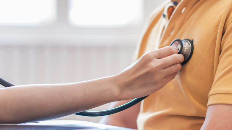 healthcare provider listening to a patient's heart