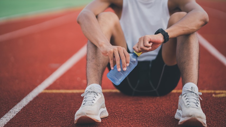 A runner sitting with water