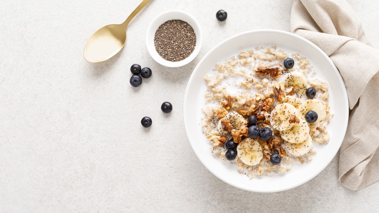 A bowl of oatmeal with fruit and nuts