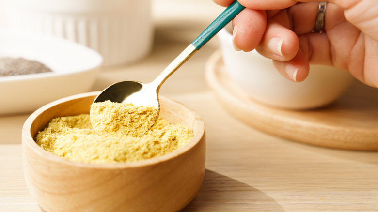 Nutritional yeast flakes in wooden bowl