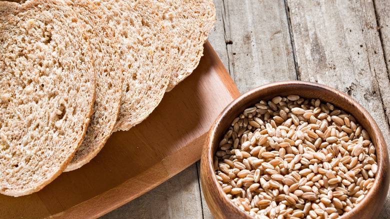 Wheat berries in bowl beside bread