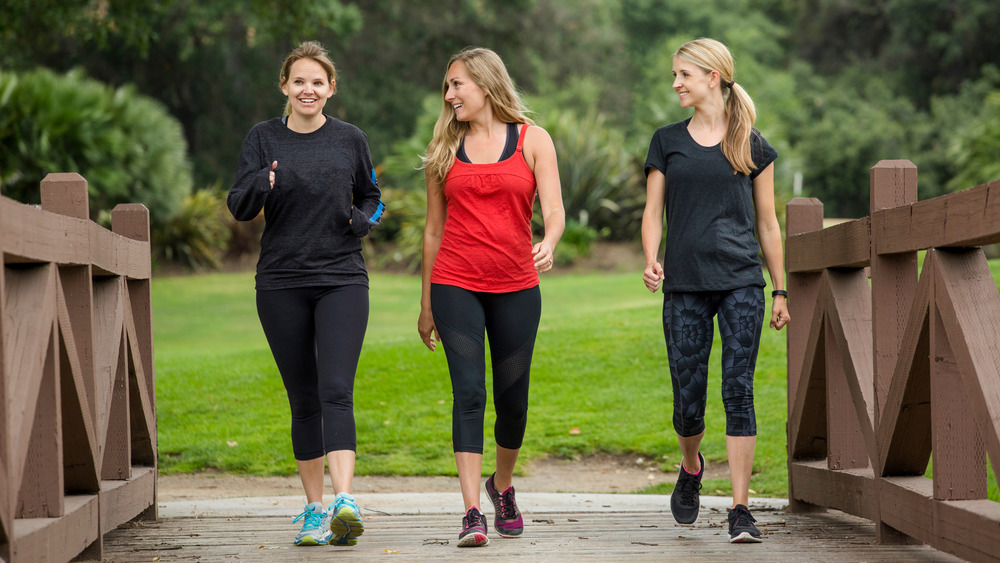 three women walking on bridge