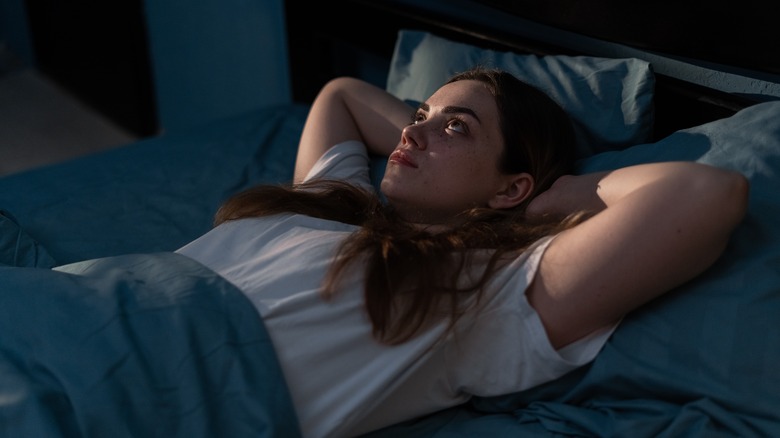 Woman lying in bed trying to stay awake