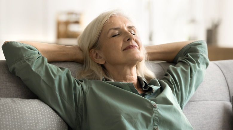 Woman relaxing on couch breathing deeply