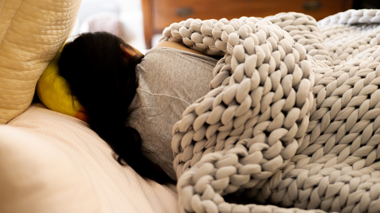 Person sleeping under a weighted blanket