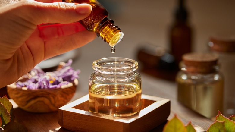 Person preparing essential oils for aromatherapy